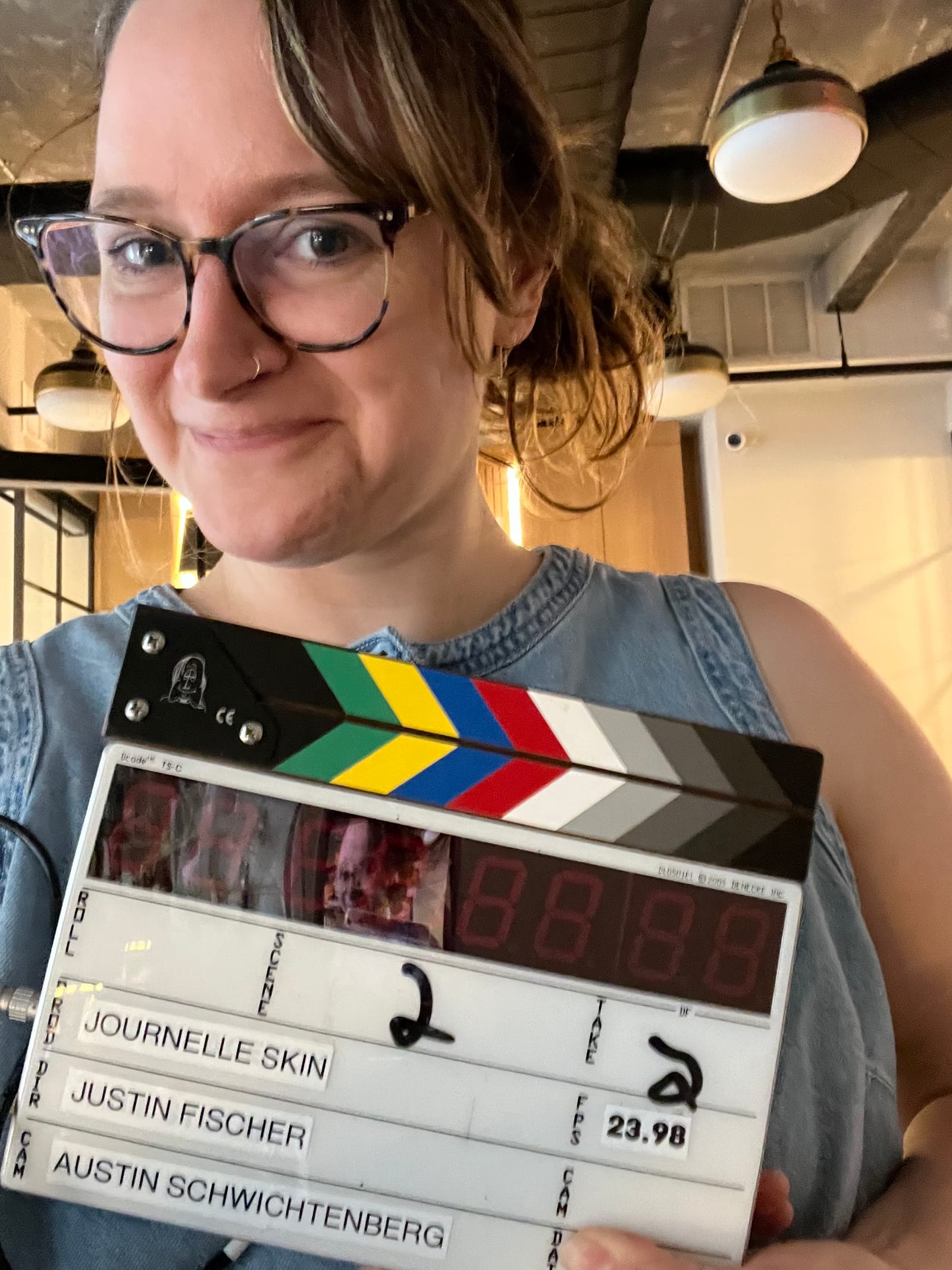 Nicole holding a film slate on a Journelle Skin shoot
